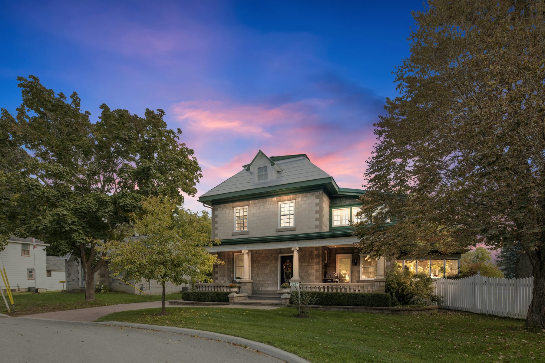 A tree-lined home in the evening, used as an illustrative property photograph